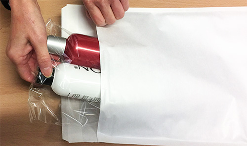 A large white padded envelope used by Simply Wigs to ship wig accessories.