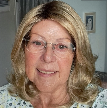 Lady smiling wearing her Carrie wig by Noriko in creamy toffee.
