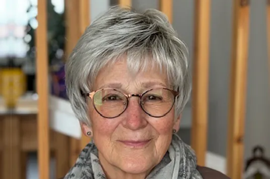 Woman with glasses wearing Ginger Comfort Lace wig in White Rooted Grey a cropped style with a side-swept fringe