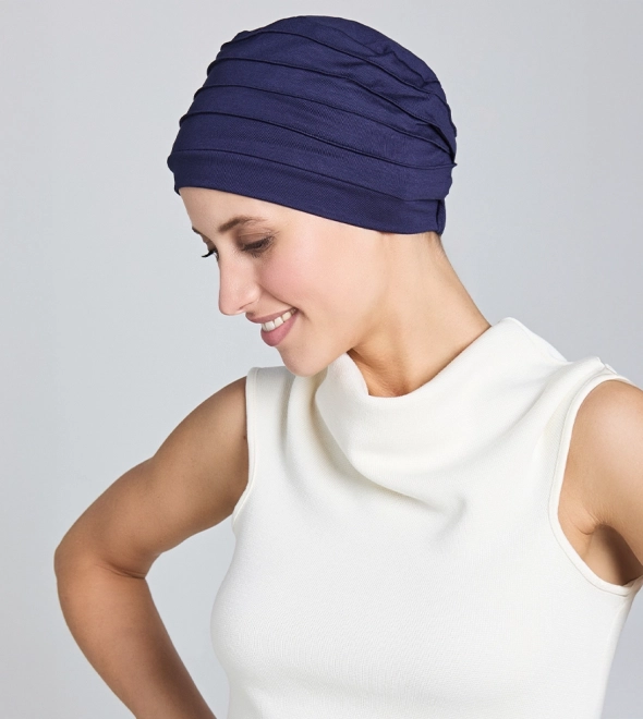 Woman wearing a modern navy hair wrap for work styled as a turban.