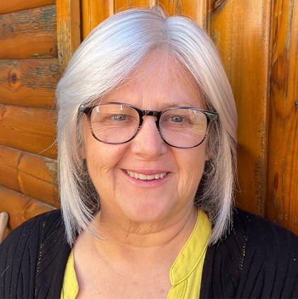 Woman wearing Tempo 100 silver grey wig, a shoulder length style with a soft fringe.